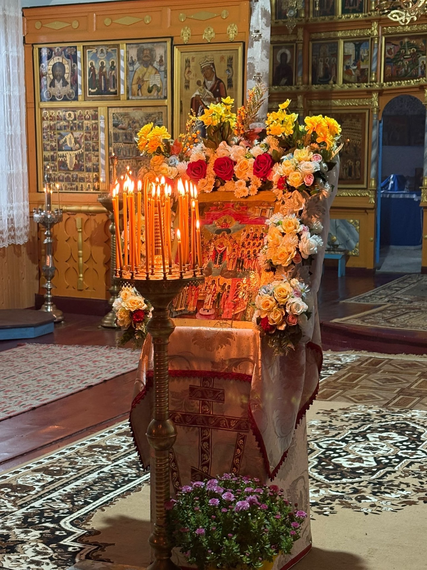The feast icon adorned with flowers and lit candles